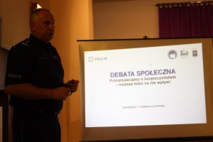 Zdjęcie kolorowe. Wystąpienie komendanta Miejskiego Policji w Kaliszu insp. Dariusza Bieńka podczas debaty społecznej w Opatówku.